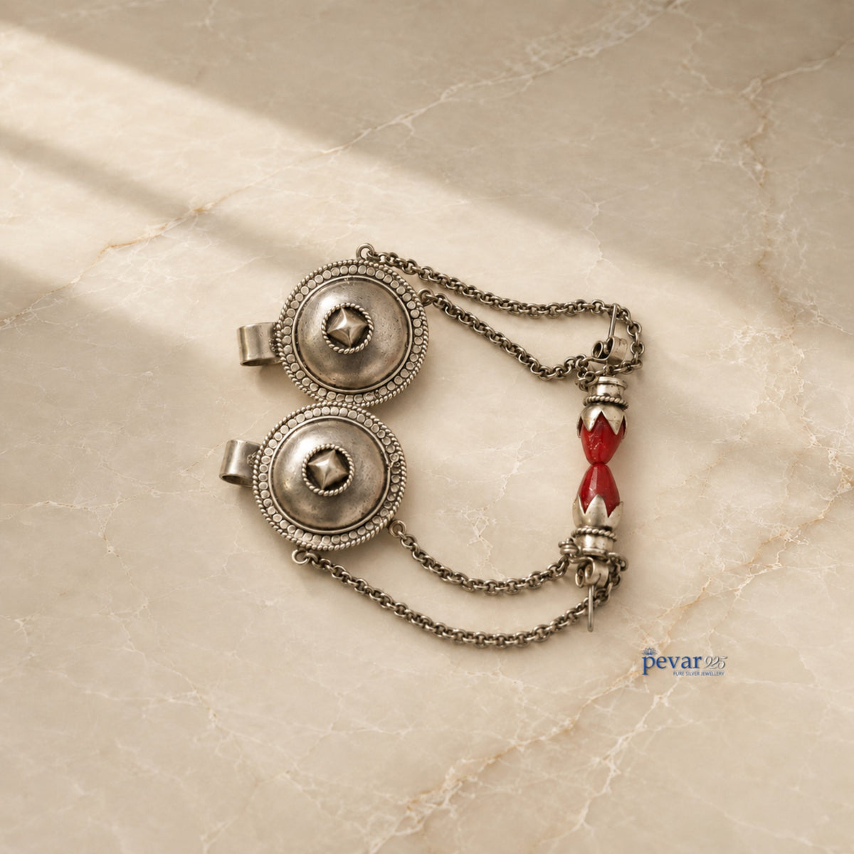 pevar925 oxidized 925 silver tribal earrings featuring intricate circular motifs and red bead accents on a marble surface