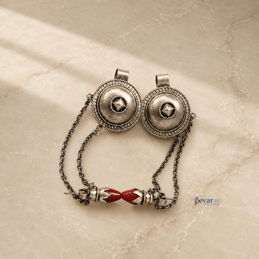 pevar925 oxidized 925 silver tribal earrings with intricate circular motifs and red stone accents on a marble surface