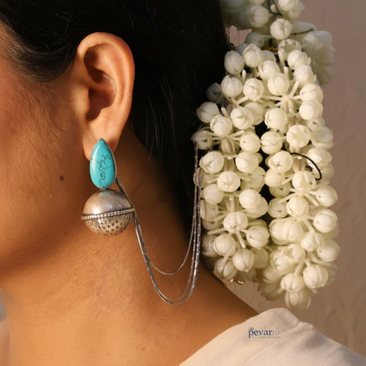 pevar925 oxidized silver bell earrings with turquoise stone worn by a woman with white jasmine hair flowers