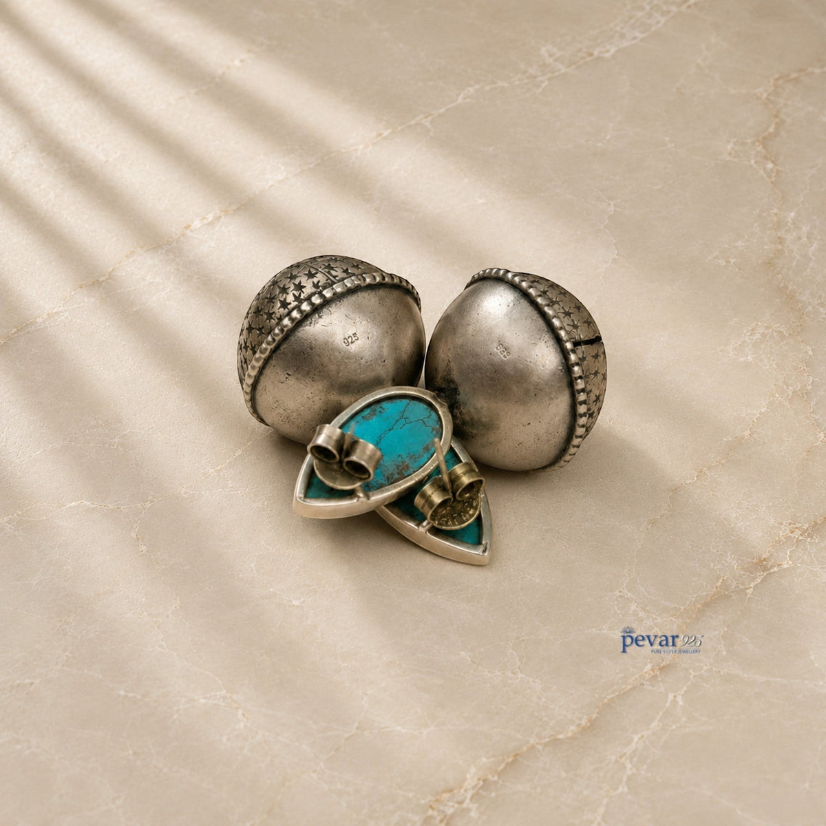 pevar925 oxidized 925 silver bell earrings featuring turquoise stones and intricate star detailing on a marble surface