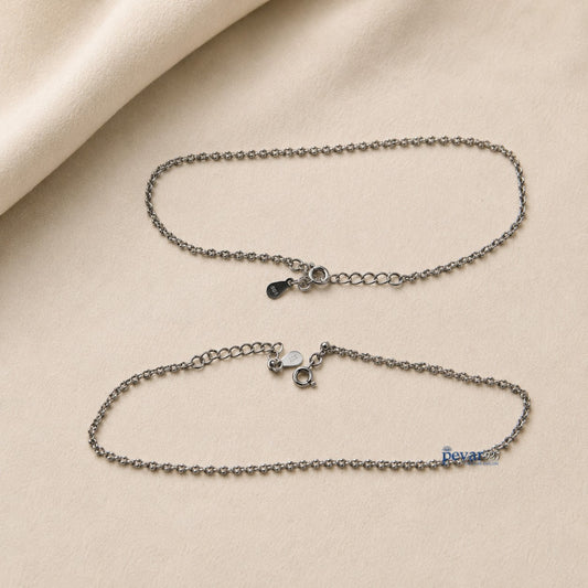 Two pevar925 sterling silver chain anklets with lobster clasps and adjustable extensions on a beige fabric background.