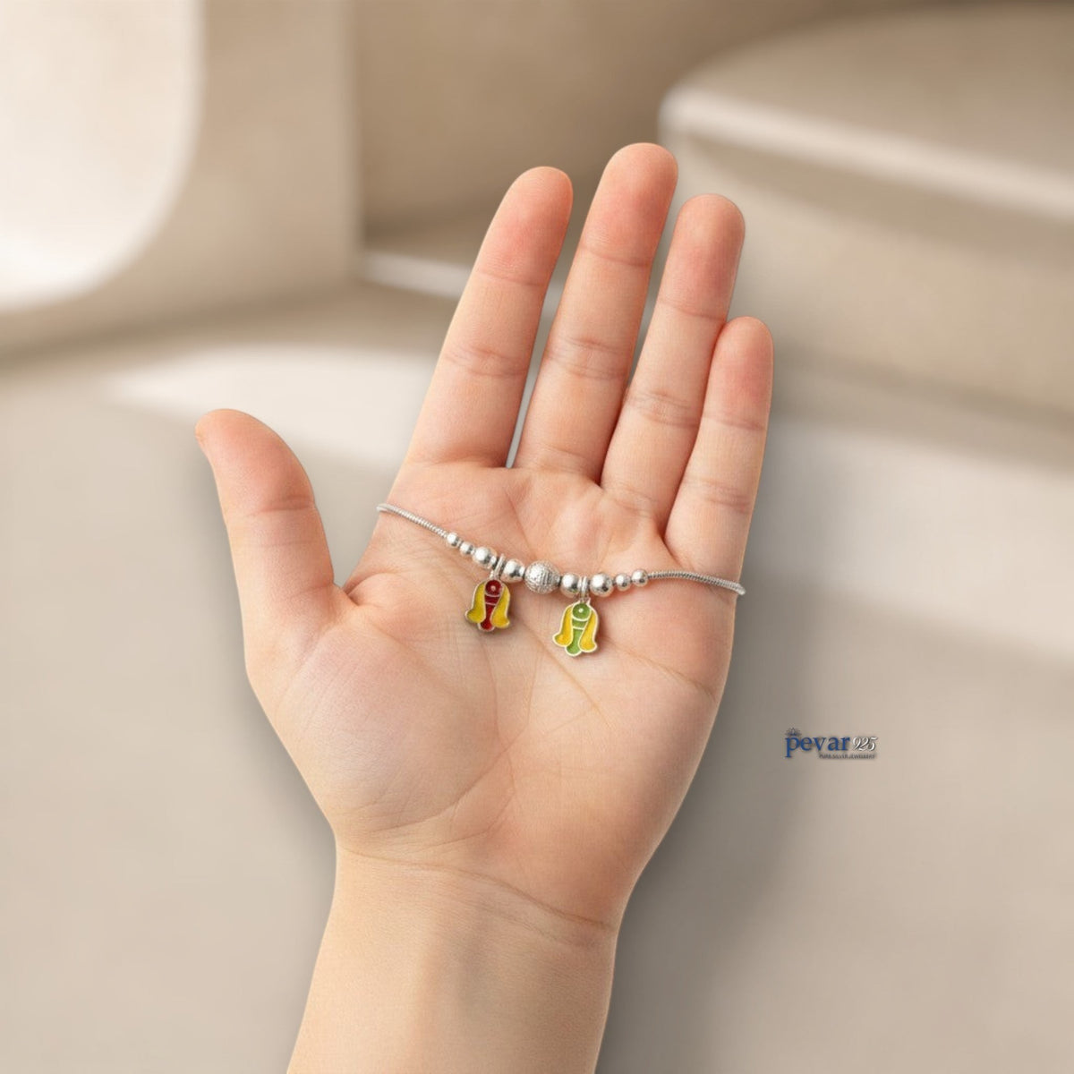 pevar925 sterling silver kids bracelet featuring colorful enamel twin fish charms and silver beads held in a hand