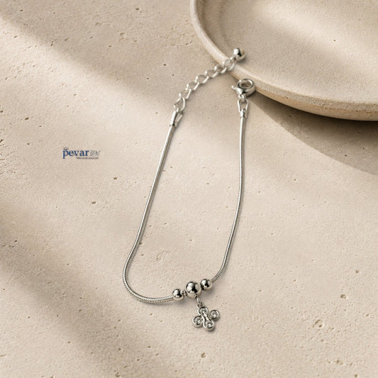 pevar925 sterling silver floral charm bracelet with a delicate chain, four-petal flower charm, and clear gemstones.