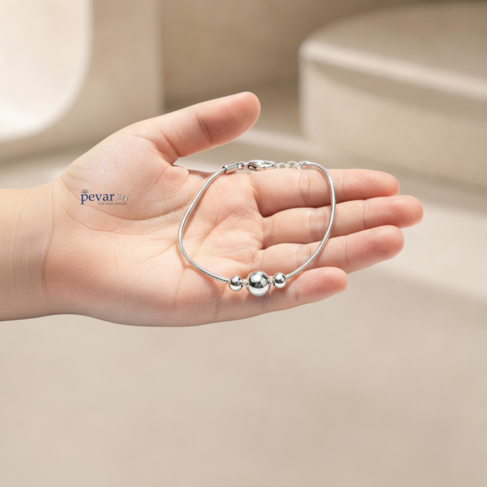 pevar925 sterling silver kids charm bracelet with three polished beads held in a child's hand