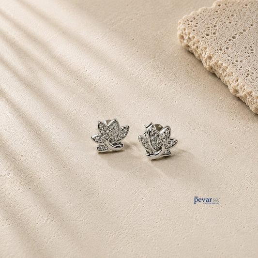pevar925 sterling silver lotus stud earrings with rhodium plating and sparkling accents on a textured stone surface