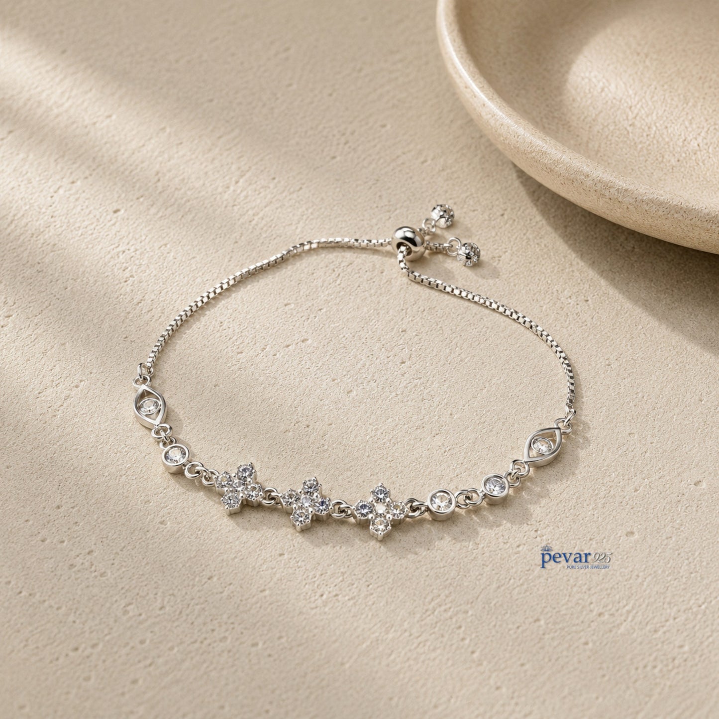 pevar925 sterling silver bracelet featuring square diamond motifs and adjustable chain on a textured beige surface