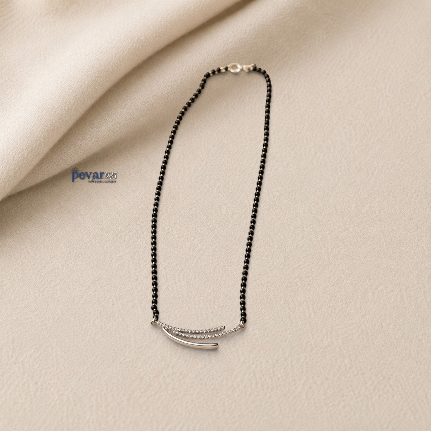 pevar925 sterling silver triple layer mangalsutra with black beads and a rhodium-plated curved motif on a beige surface